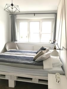 Apartament Prusa No 9 في تورون: غرفة نوم بيضاء مع سرير كبير مع نافذة