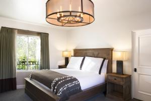 a bedroom with a large bed and a chandelier at North Block Hotel in Yountville