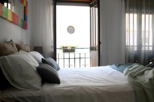 a bedroom with a white bed with a large window at Peixe Agulha in Tavira