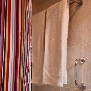 a bathroom with a towel hanging on a shower curtain at Peixe Agulha in Tavira