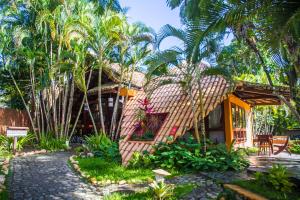 a house with palm trees in front of it at Pousada Arraial Candeia in Arraial d'Ajuda