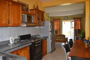 a kitchen with a stove and a refrigerator at Buccoo Reef View in Buccoo