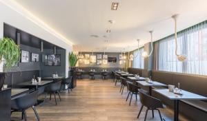 un restaurant avec des tables et des chaises dans une salle dans l'établissement Hotel Bliss, à Francfort-sur-le-Main