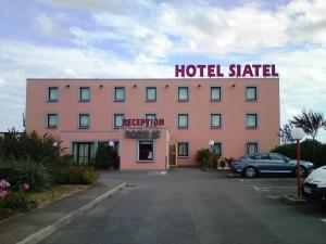 um grande edifício de hotel cor-de-rosa com uma placa em Hotel Siatel Metz em Norroy-le-Veneur