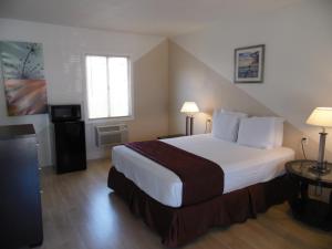 Tempat tidur dalam kamar di Hi-Way Host Motel