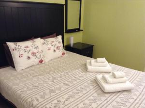 ein Schlafzimmer mit einem Bett mit zwei Handtüchern darauf in der Unterkunft Apartment Lisbon Airport in Lissabon
