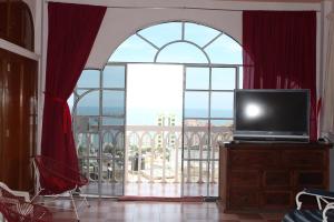 a television sitting on a dresser in front of a large window at Condominio AcaGutty 1B in Acapulco