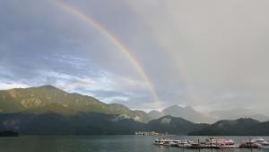 a rainbow over a lake with boats in the water at Sun Fog Hotel in Yuchi