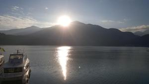 a boat in the water with the sun in the background at Sun Fog Hotel in Yuchi