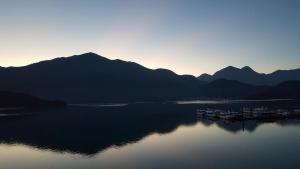 a group of boats on a lake with mountains at Sun Fog Hotel in Yuchi
