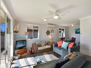 a living room with two couches and a tv at The Nautical House in The Entrance