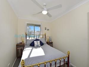 a bedroom with a bed and a ceiling fan at The Nautical House in The Entrance