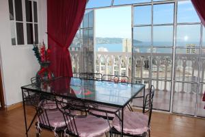 a glass table and chairs in a room with a large window at Condominio AcaGutty 1B in Acapulco