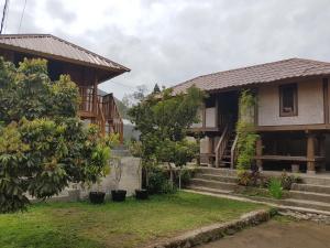 une maison avec des escaliers et des arbres devant elle dans l'établissement Radiya Guesthouse, à Sembalun Lawang