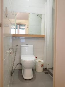a bathroom with a white toilet and a mirror at The Leaf House in Manila