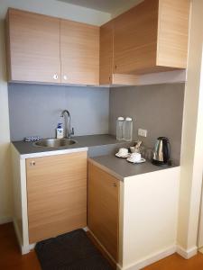 a kitchen with wooden cabinets and a sink at The Leaf House in Manila