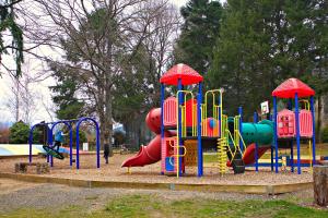 een park met een speeltuin met een glijbaan en een speelplaats bij Discovery Parks - Bright in Bright