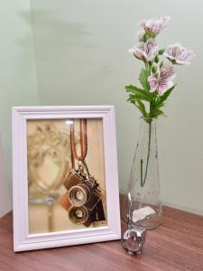 a picture of a camera next to a vase with flowers at STSP Guest House in Xinshi