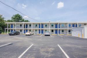 Motel 6-Glassboro, NJ - Rowan University في Glassboro: مبنى كبير به سيارات تقف في موقف للسيارات