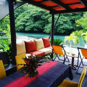 a porch with a couch and chairs and a table at Salt Lake Lodge in Savusavu