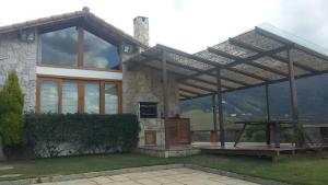 a house with a pergola in front of it at Chalé da Manga Larga in Itaipava