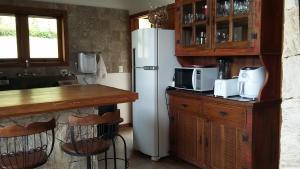 イタイパバにあるChalé da Manga Largaの白い冷蔵庫と電子レンジのあるキッチン