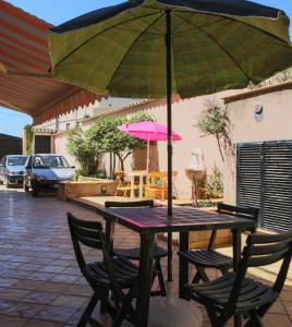 een tafel met stoelen en een parasol op een patio bij Casa di Luca in Agrigento