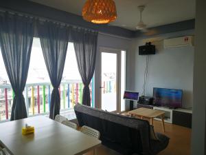 een woonkamer met een tafel en een groot raam bij Pulau Ketam D'island beds&cafe in Bagan Pulau Ketam