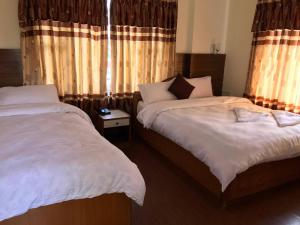 Ліжко або ліжка в номері Hotel Himalayan Inn