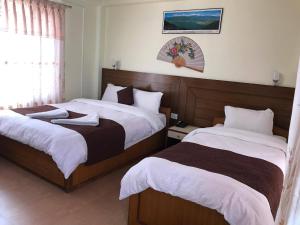 Ліжко або ліжка в номері Hotel Himalayan Inn