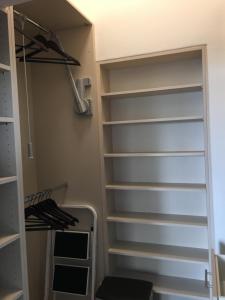 a walk in closet with white shelves at Central Suites Frankfurt in Frankfurt