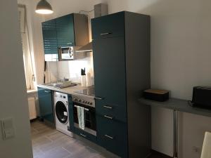 a kitchen with a washing machine and a green cabinet at Central Suites Frankfurt in Frankfurt