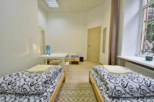a room with two beds and a table at Laisves Avenue Hostel "Easy Kaunas" in Kaunas