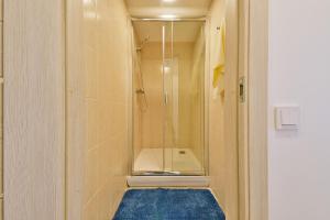 a bathroom with a shower and a blue rug at Laisves Avenue Hostel "Easy Kaunas" in Kaunas +17 photos