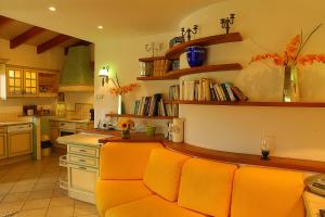 una cocina con sillas naranjas y una barra con libros en Villa Cartarana, en Bonifacio