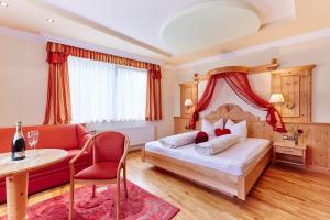 1 dormitorio con cama, mesa y sofá en Landhotel Zellerhof en Lunz am See