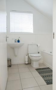a white bathroom with a toilet and a sink at 6 on Horatio in Simonʼs Town