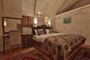 OrtahisarにあるThree Doors Cappadociaのベッドルーム(ベッド1台、テーブル、鏡付)