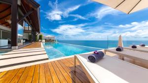 a swimming pool with a view of the ocean at Villa Paradiso in Nai Thon Beach