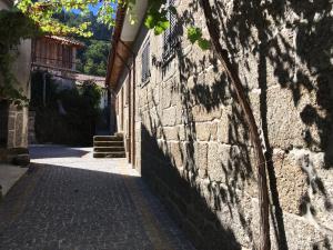 Une allée à l'ombre d'un mur en pierre dans l'établissement Casa dos Patricios, à Terras de Bouro