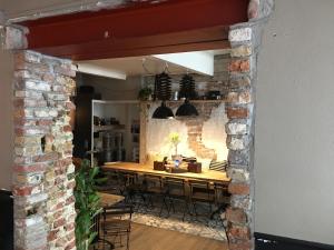 a dining room with a table and a brick wall at bednextdoor in Middelburg