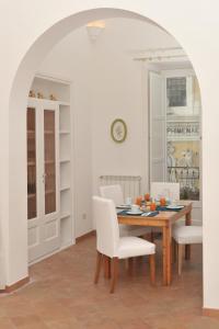 a dining room with a wooden table and white chairs at Il Sagrato - Ravello Accommodation in Minori