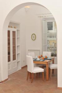 ミノーリにあるIl Sagrato - Ravello Accommodationのダイニングルーム(木製テーブル、白い椅子付)