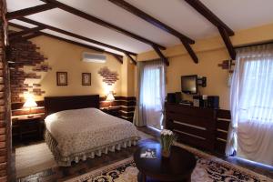 1 dormitorio con 1 cama en una habitación con vigas en Park-Hotel Butenko Stable, en Protsev