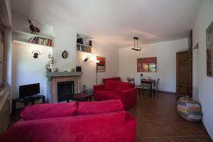 - un salon avec des canapés rouges et une cheminée dans l'établissement Villino Alborella, à Verbania