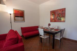 - un salon avec une table et un canapé rouge dans l'établissement Villino Alborella, à Verbania