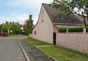 a white house with a fence next to a street at Le Mas des Loups in Arpajon