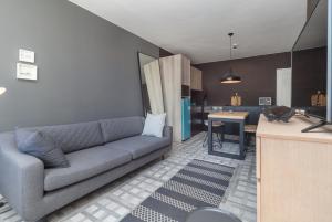 ein Wohnzimmer mit Sofa und eine Küche in der Unterkunft Keerom 66 - Beautiful modern apartment in heart of Cape Town in Kapstadt