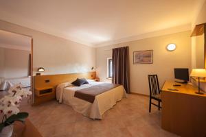 ペスキエーラ・デル・ガルダにあるHotel Bel Sitoのベッドとデスクが備わるホテルルームです。