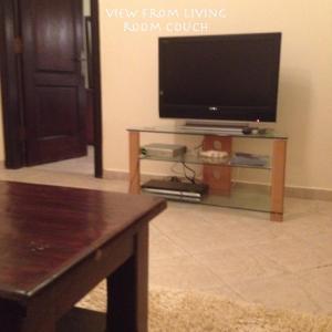 a living room with a flat screen tv on a table at Apartment at Palm Beach Piazza in Hurghada